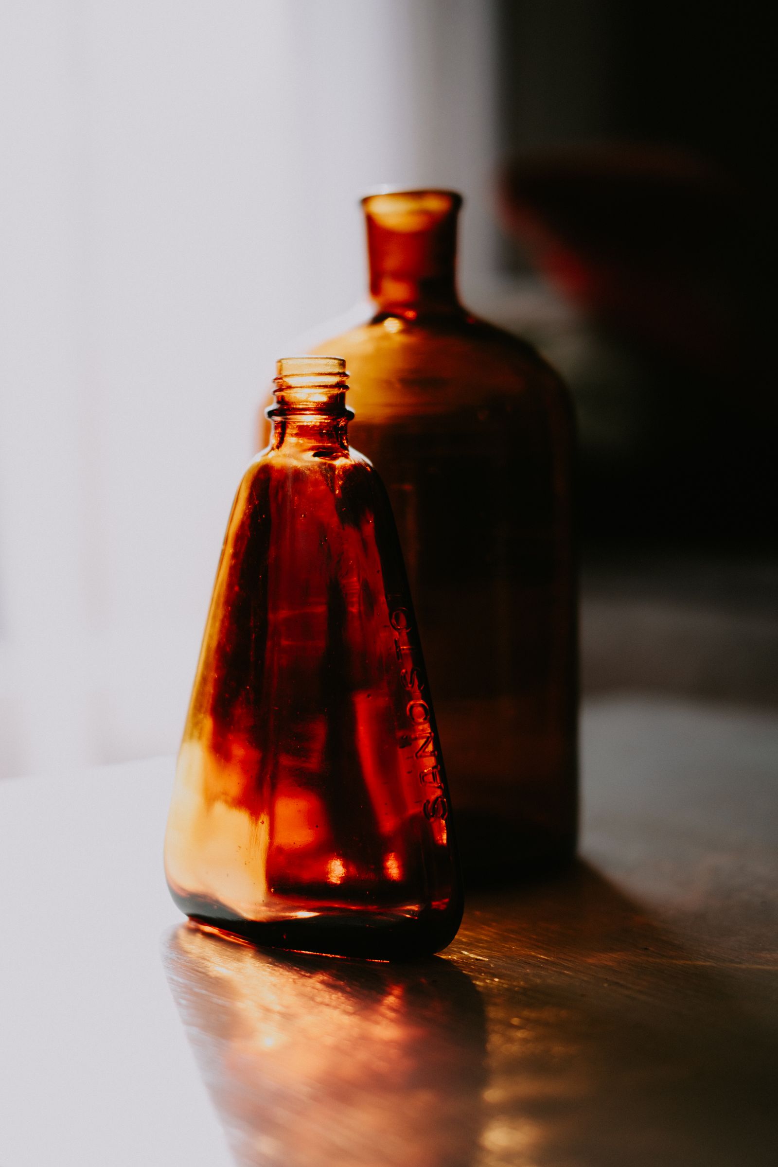Amber glass cleaning bottles lined up in sunlight